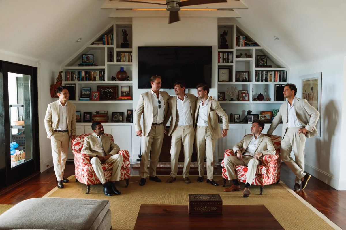 Groomsmen in cream suits posed in the living room before the ceremony