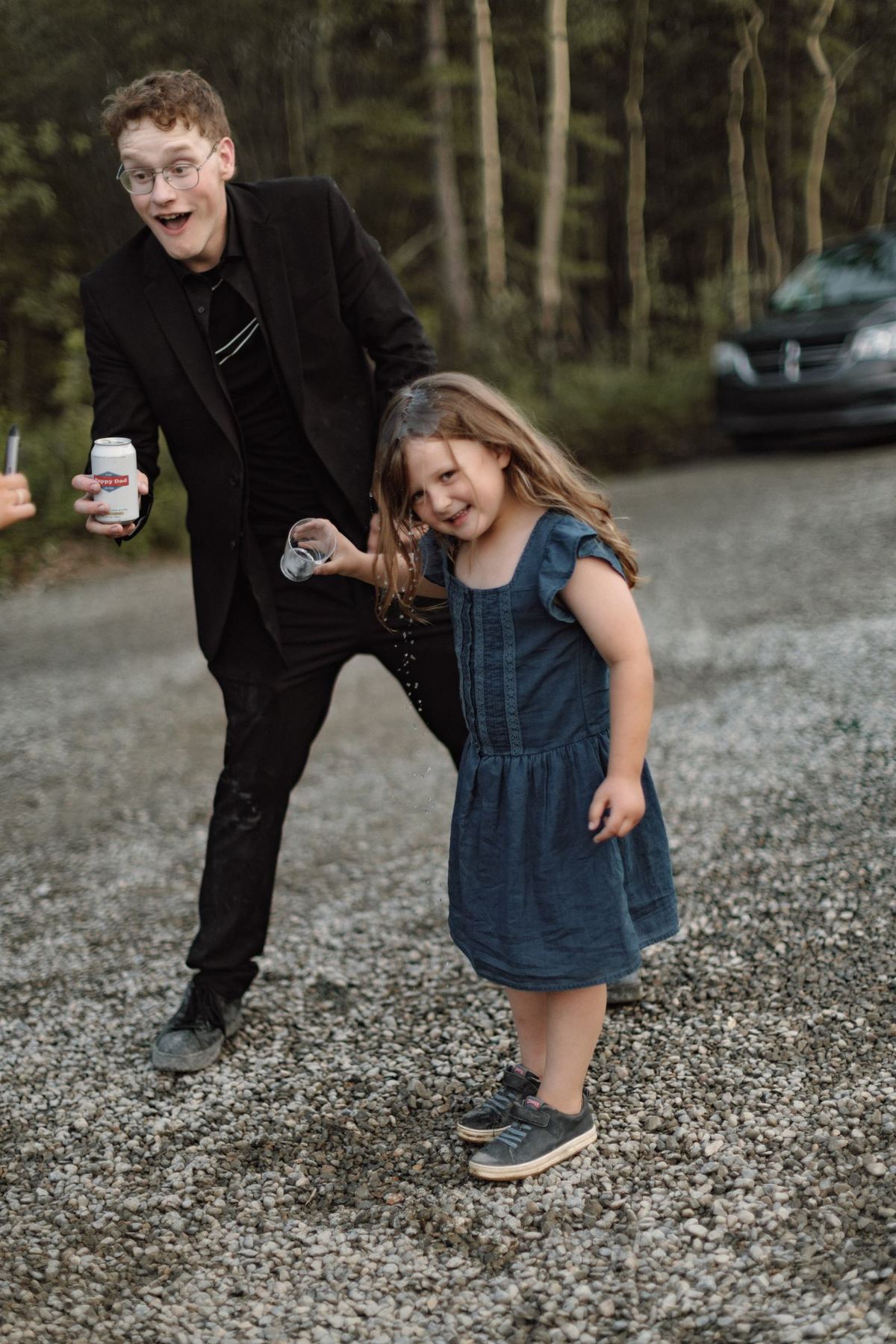 Guest dancing with a young girl at a mountaintop wedding reception