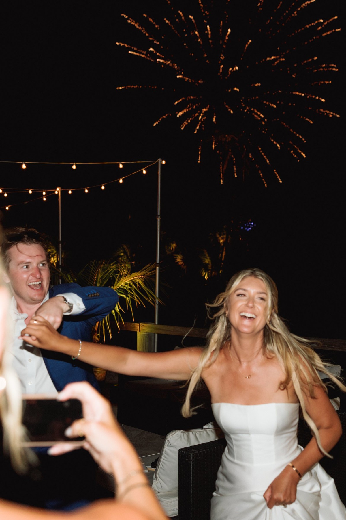 Paige laughs on the dance floor as fireworks break over the terrace on Hawkins Island, Bermuda