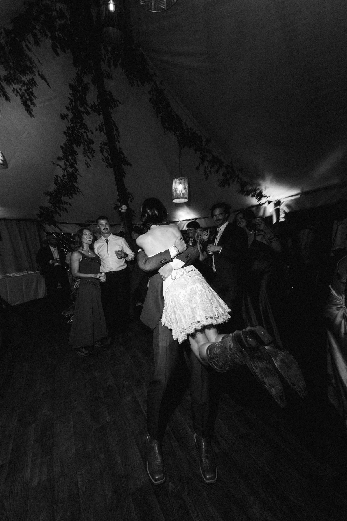 Owen lifts Devin on the dance floor late in the night at a mountain ranch among the aspens, black and white