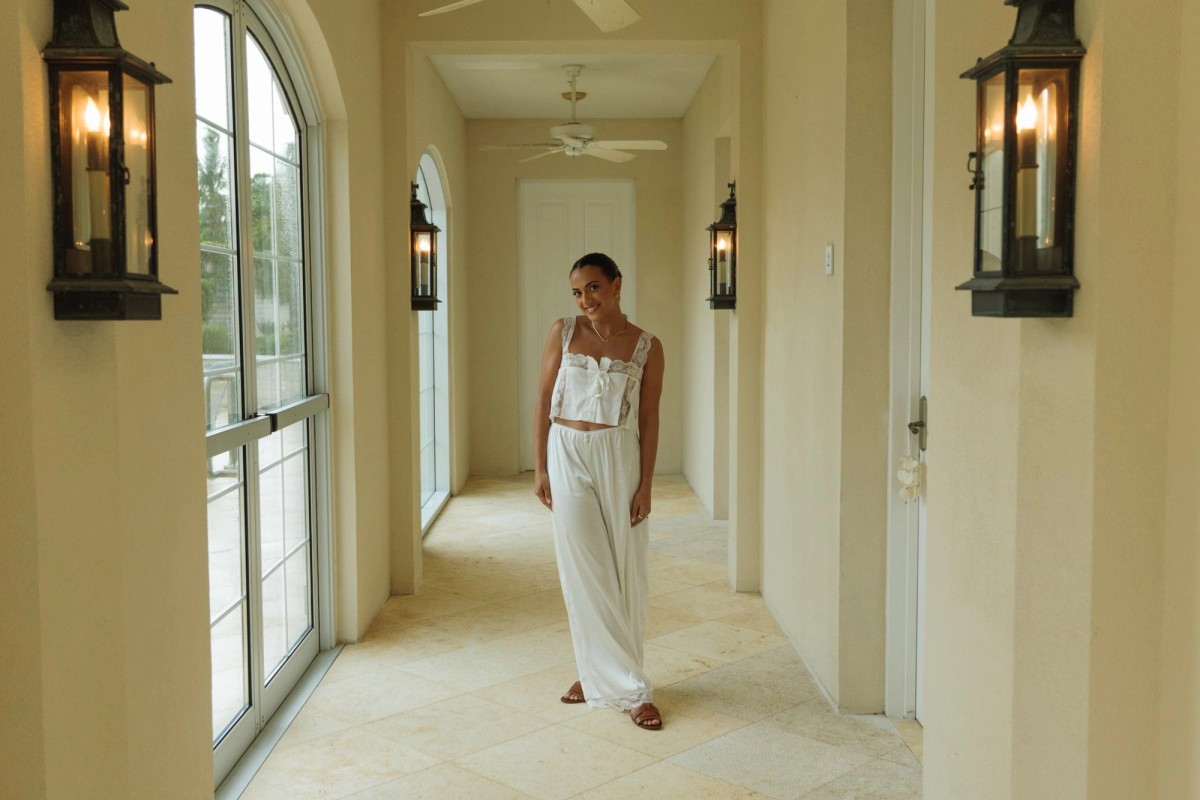 Bride in a white two piece walking down a sunlit arched hallway at Rosewood Bermuda