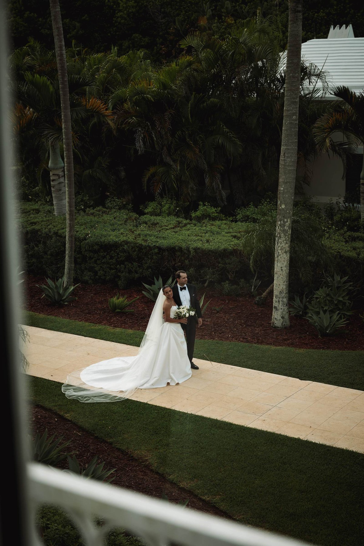 Couple seen through a window on the garden path at dusk at Rosewood Bermuda