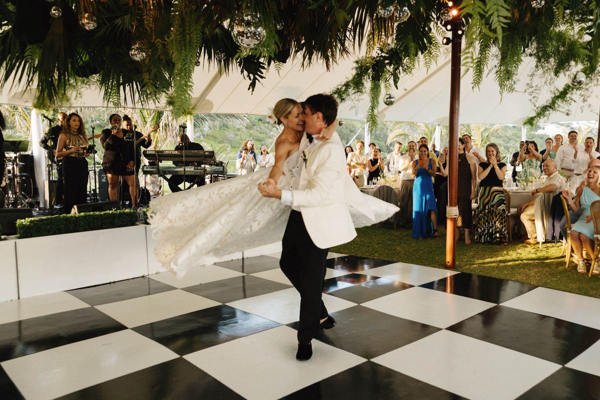 First dance on a black and white checkerboard floor with the band playing