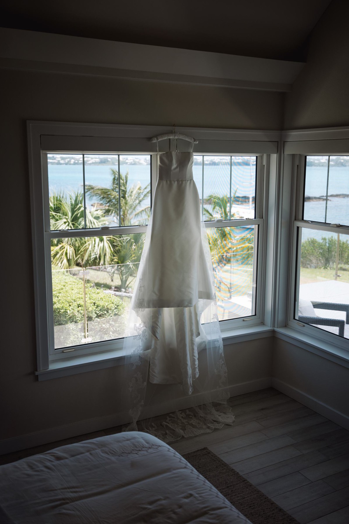 Paige's wedding dress hangs in the window of the bridal suite overlooking the water on Hawkins Island, Bermuda