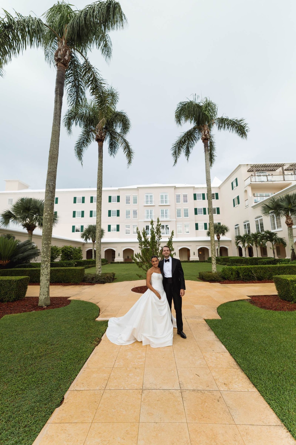 Couple on the palm lined path in front of the hotel at Rosewood Bermuda