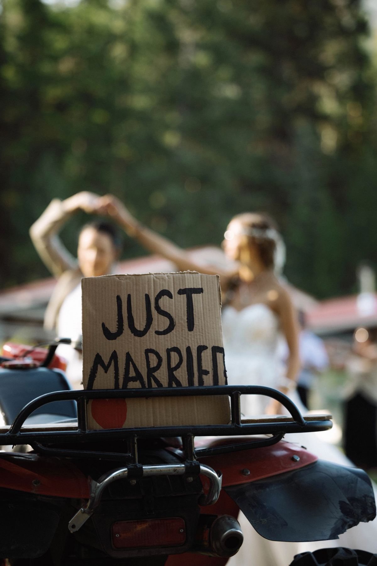 Hand-lettered Just Married sign propped on the back of a quad bike