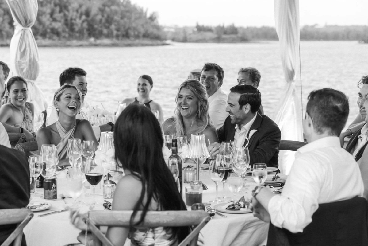 Guests share a laugh at dinner under the tent on Hawkins Island, Bermuda, black and white