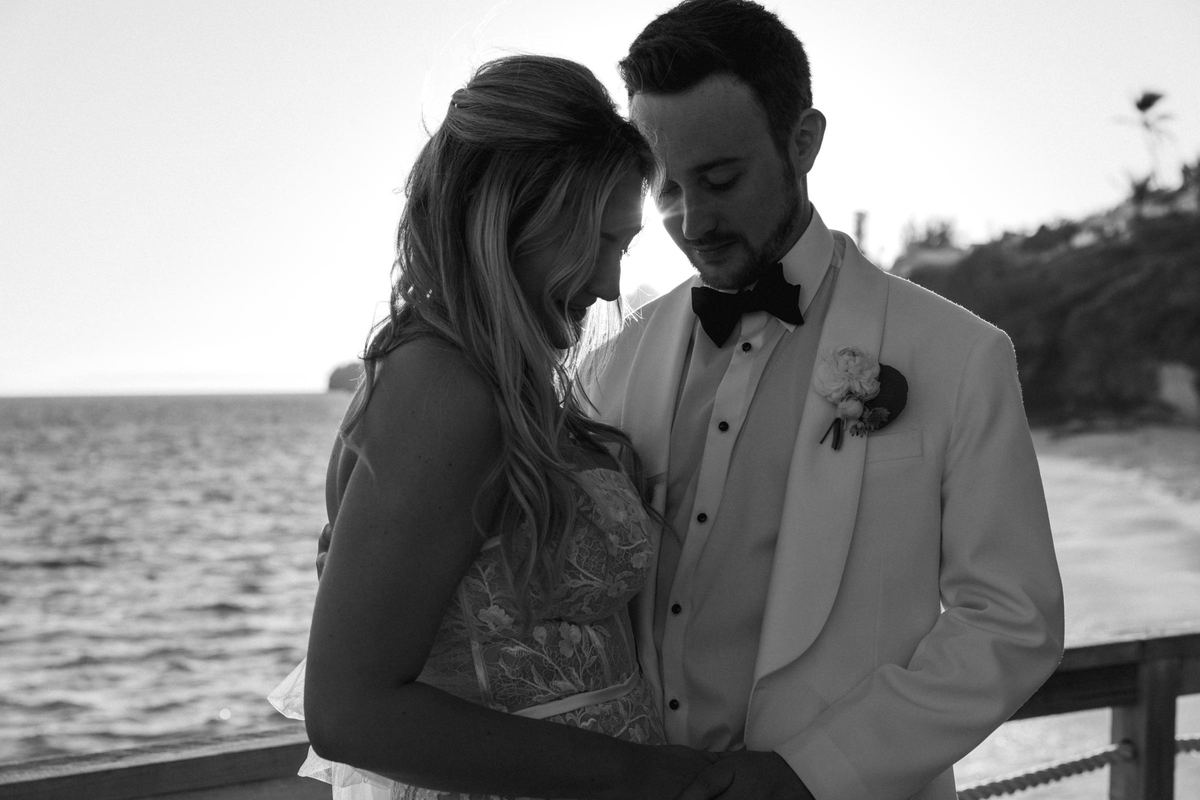 Black and white intimate close portrait of couple at golden hour beside Bermuda ocean