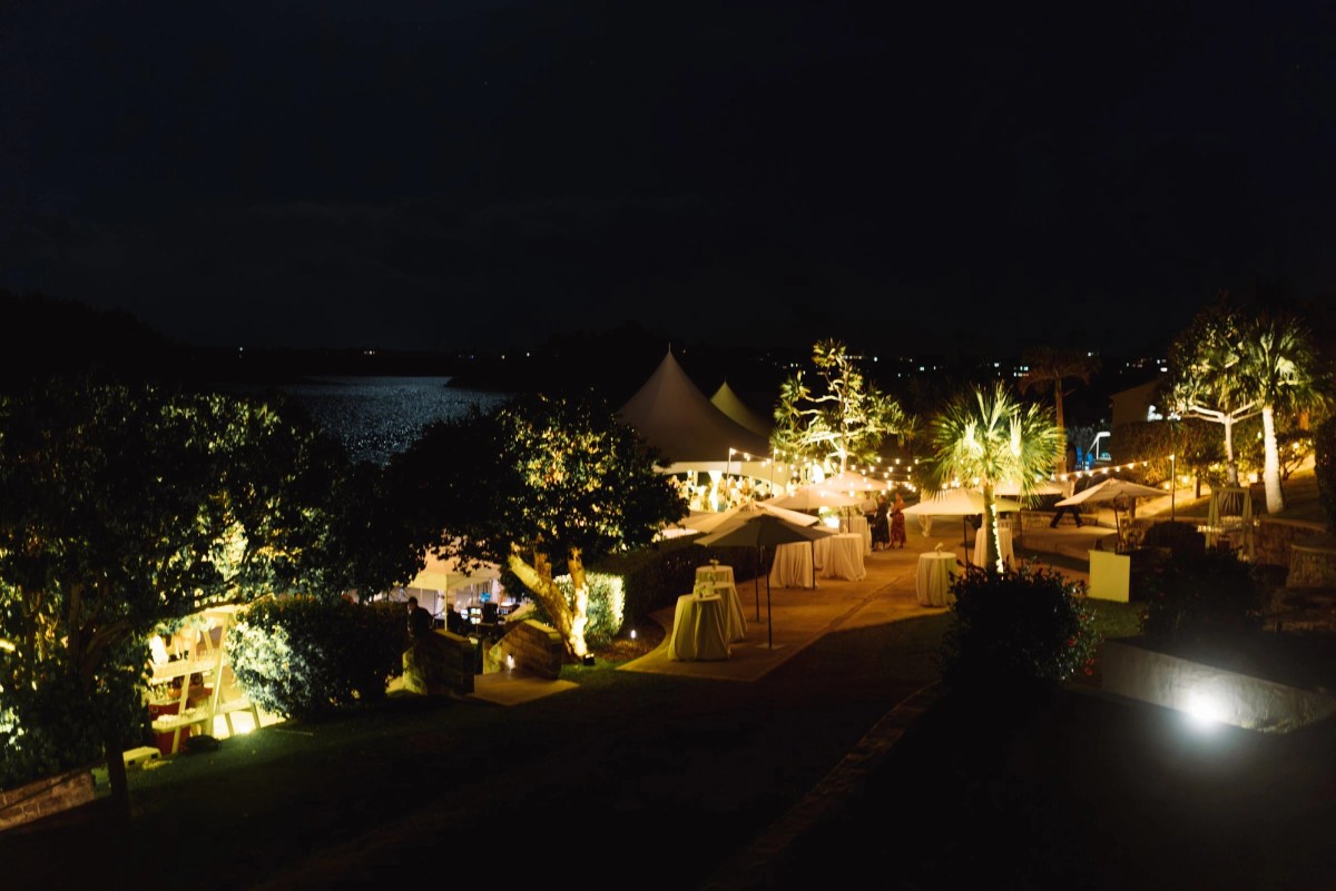 The reception glows among the trees above the water at night on Hawkins Island, Bermuda