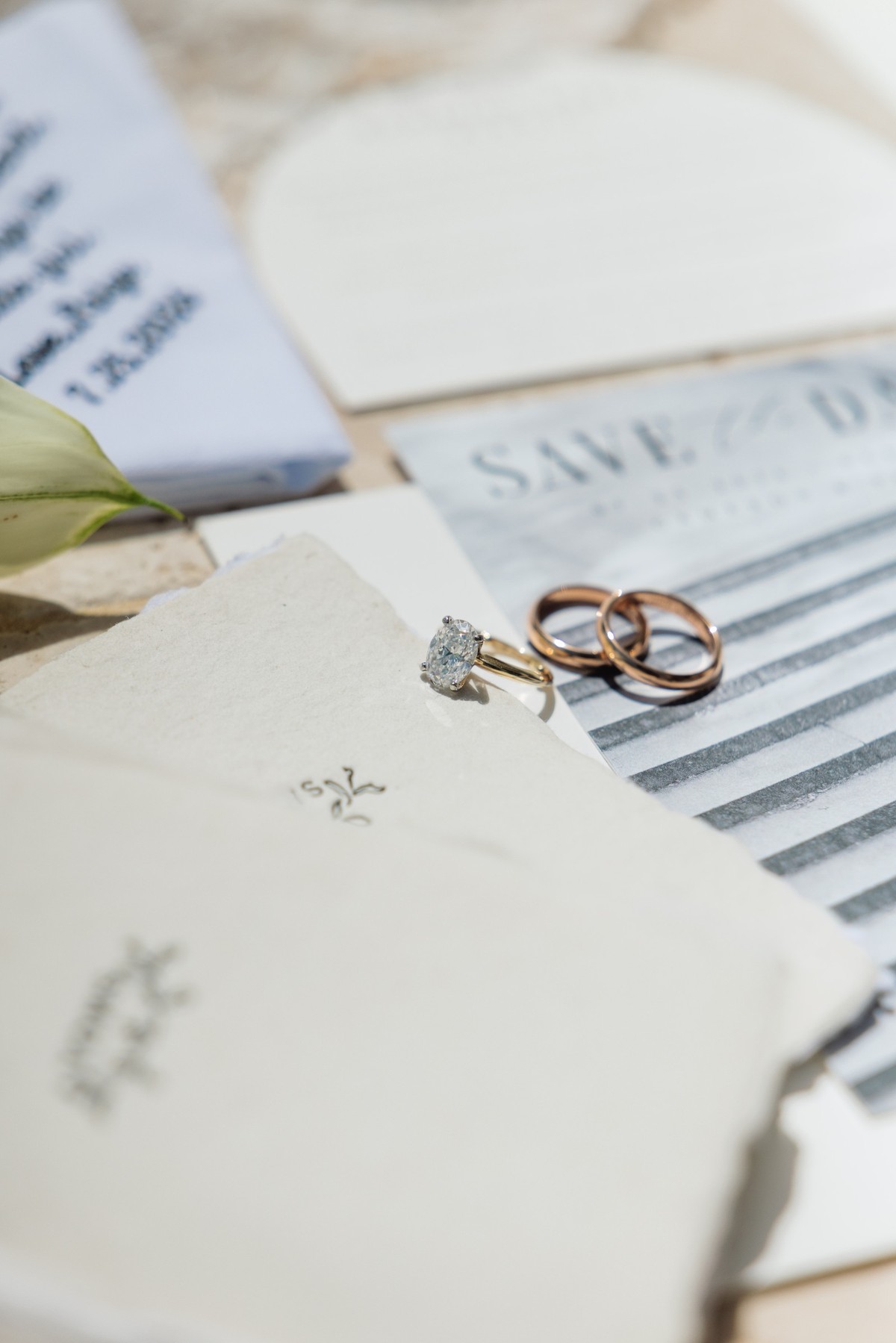 Engagement ring and wedding bands resting on the wedding stationery on Hawkins Island, Bermuda