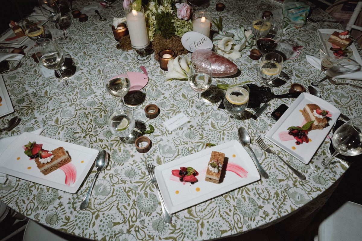 Elegant table setting with dessert and floral arrangement at wedding reception
