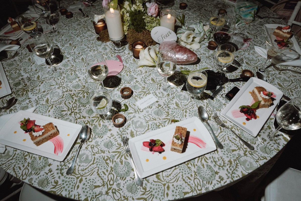 Elegant table setting with dessert and floral arrangement at wedding reception