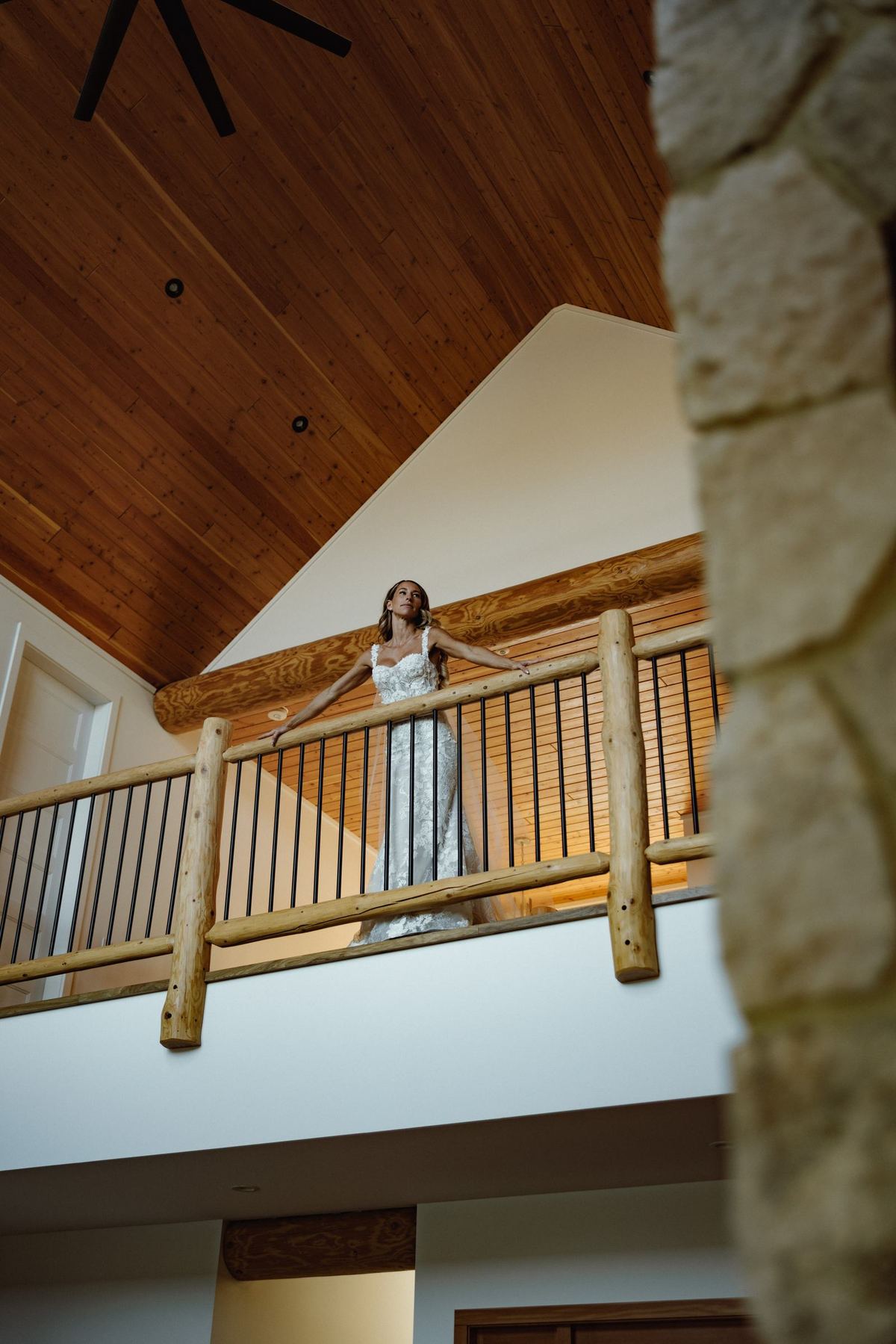 Bride on the balcony above the great room of the wedding house