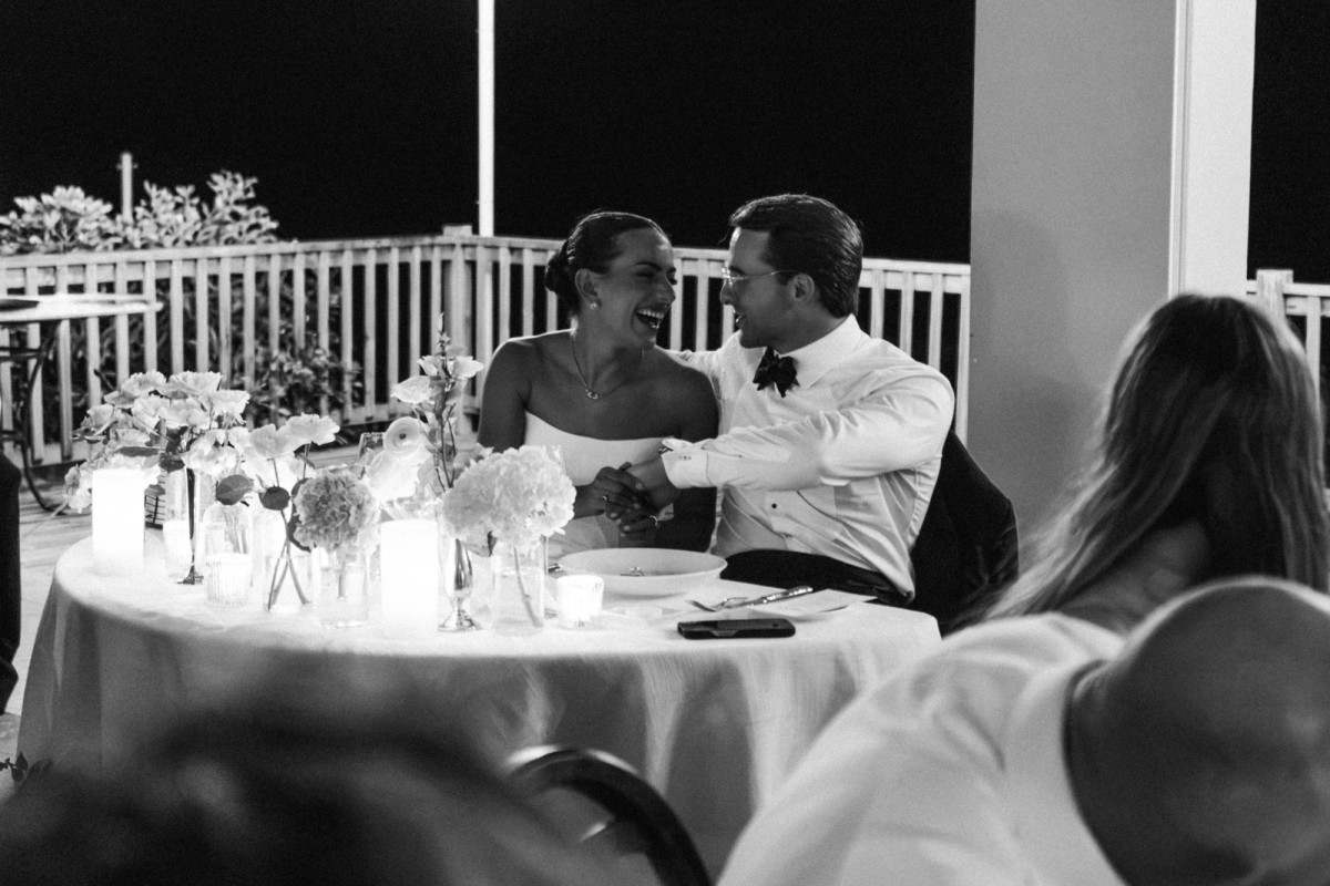 Couple laughing together at their sweetheart table at Rosewood Bermuda, black and white