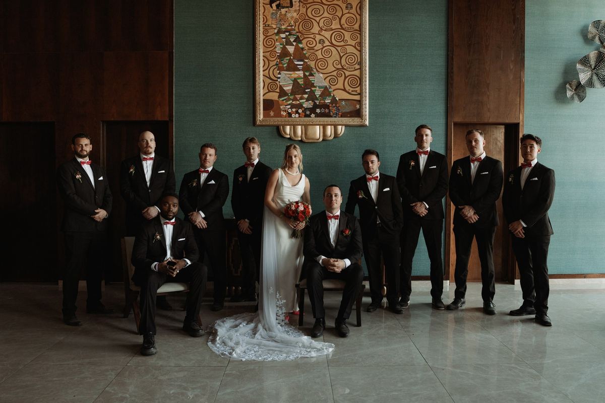Bride with groomsmen editorial portrait in teal vintage room at destination wedding