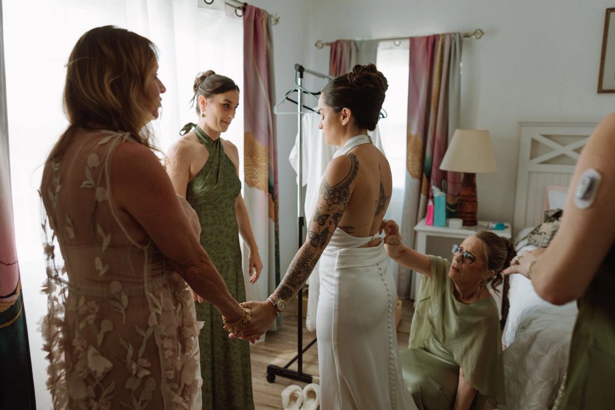 Bride holding hands with her people in the getting ready room