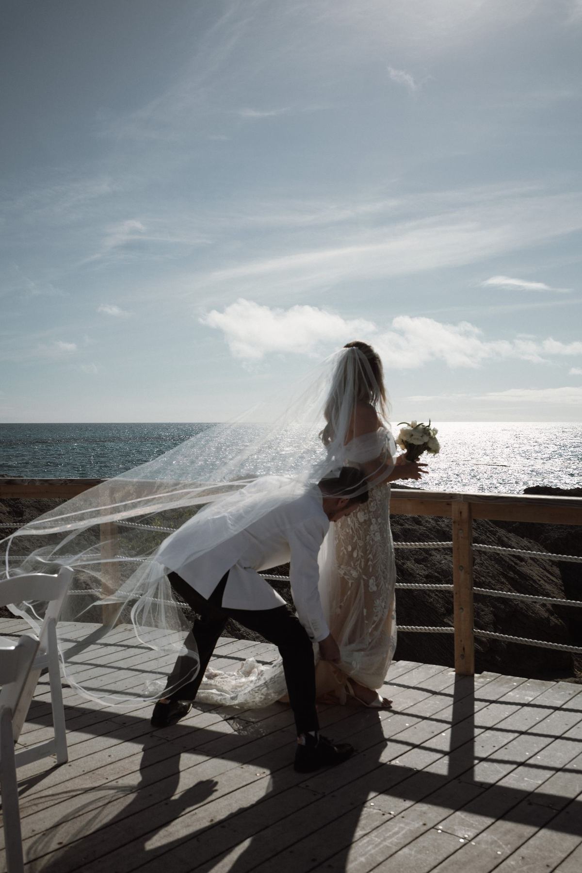 Bride catching wind in dramatic veil moment during Bermuda wedding ceremony