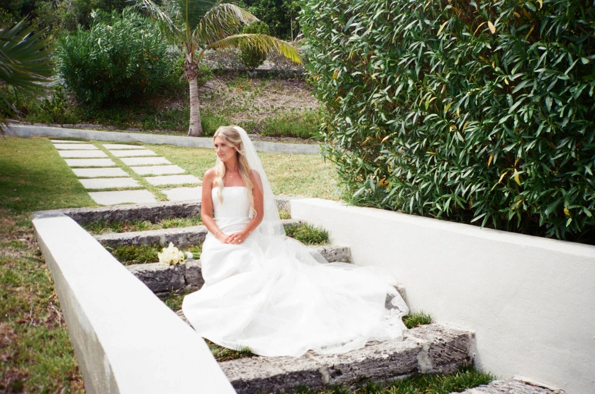 Paige sits on the terraced garden steps in her gown on Hawkins Island, Bermuda, on film