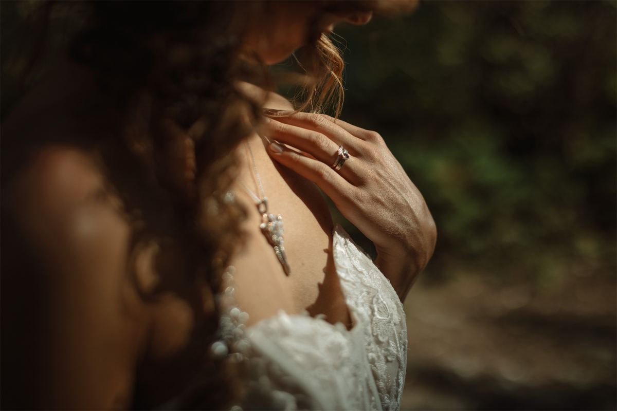 Detail of a bride's beaded gown, bare shoulder and delicate tattoo