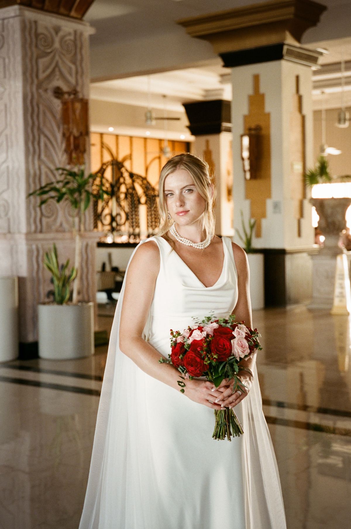 Bride holding bouquet in elegant hotel lobby portrait at destination wedding