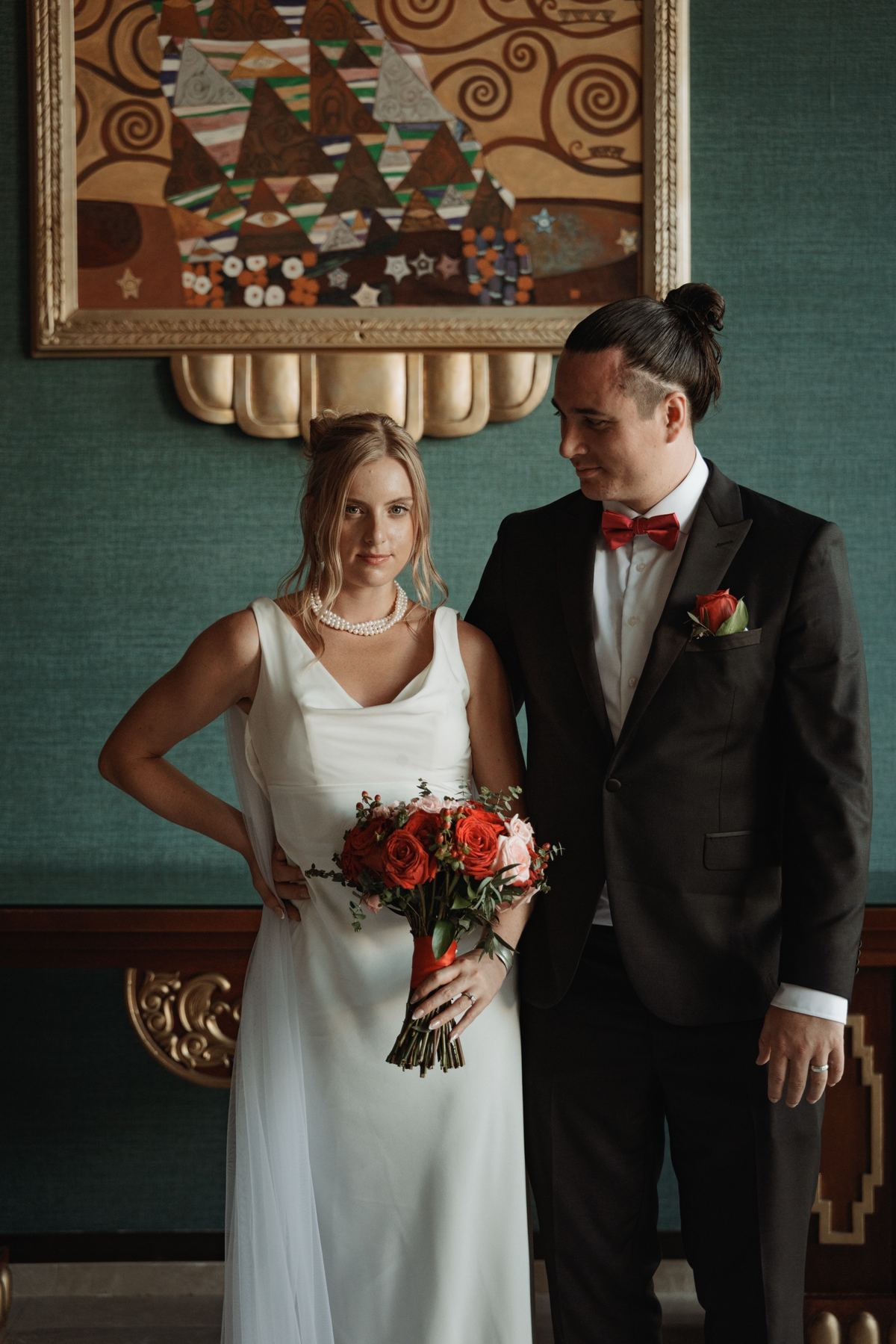 Bride and groom editorial portrait in teal vintage room