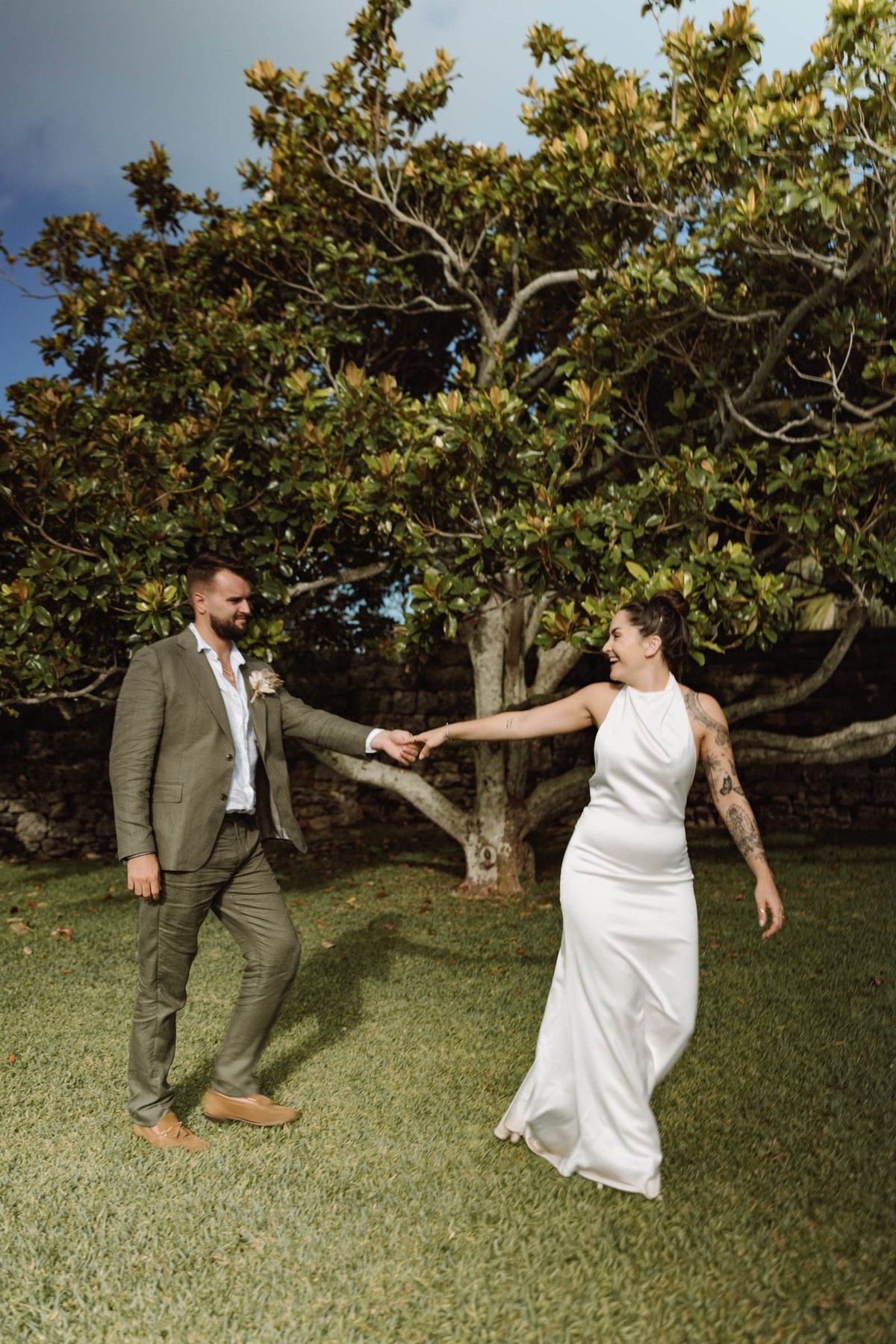 Bride spinning on the lawn with the groom under a Bermuda fig tree