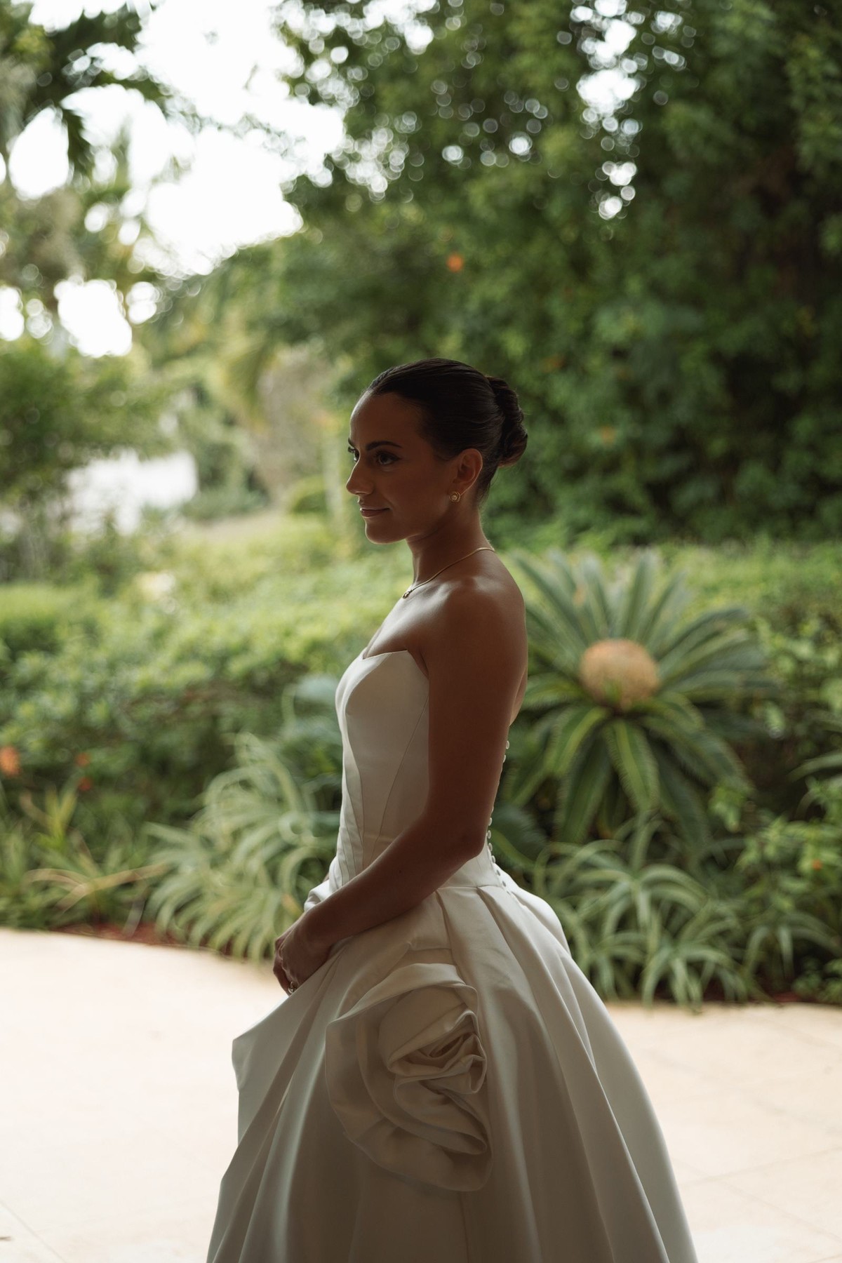Bride in profile against the tropical garden in her strapless gown at Rosewood Bermuda