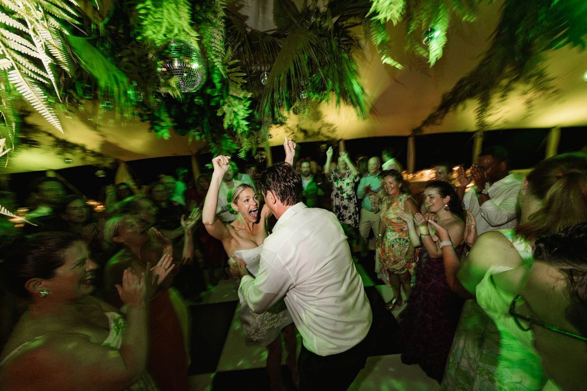 Packed dance floor under green light at a Bermuda wedding reception