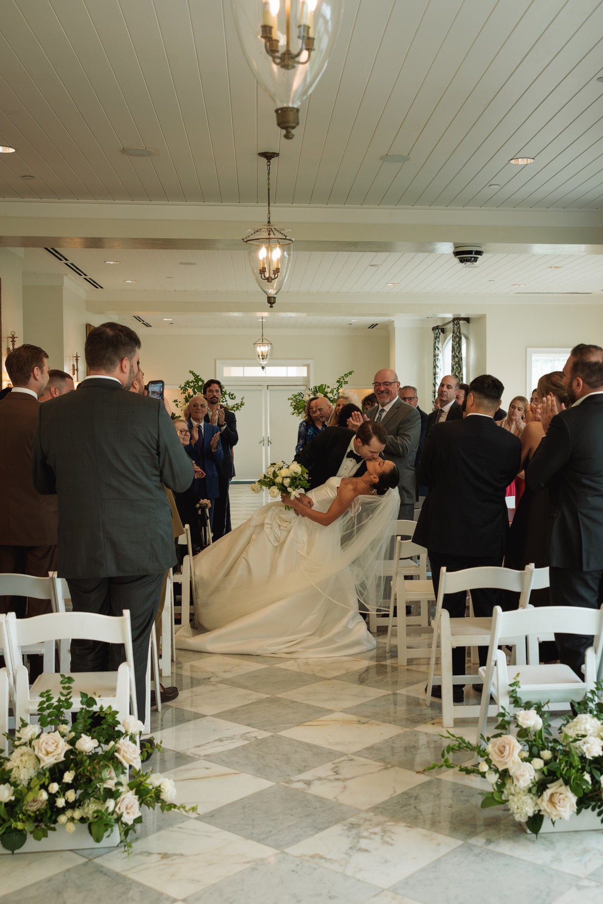 Groom dipping the bride in the aisle as guests cheer at Rosewood Bermuda