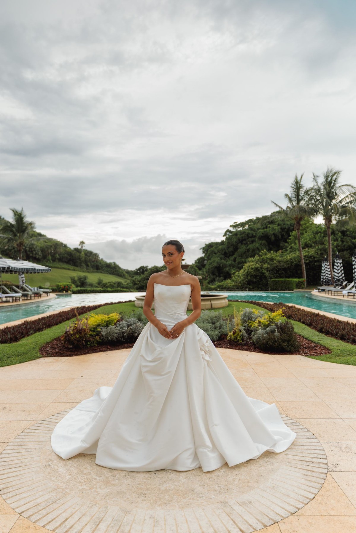 Bride in her ballgown standing before the pool and gardens at Rosewood Bermuda