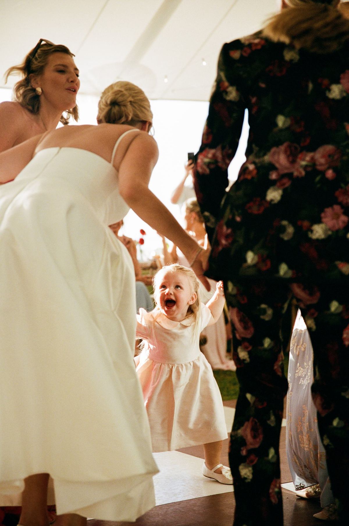 Bride laughing with the flower girl during a Bermuda wedding reception