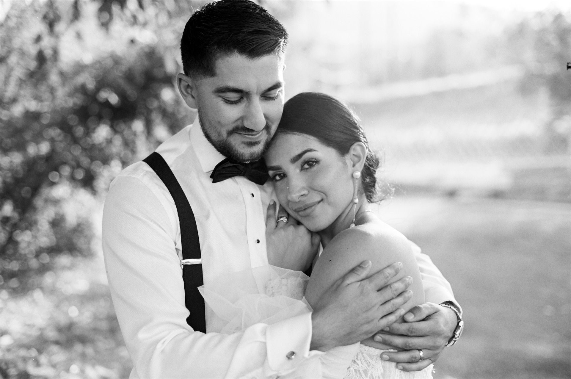 Black and white close portrait of the groom holding his bride
