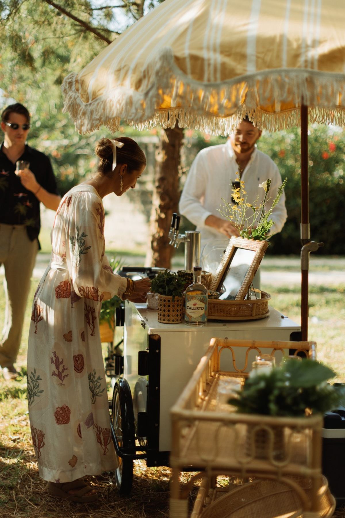 Guests being served drinks from a vintage bar cart on the garden lawn