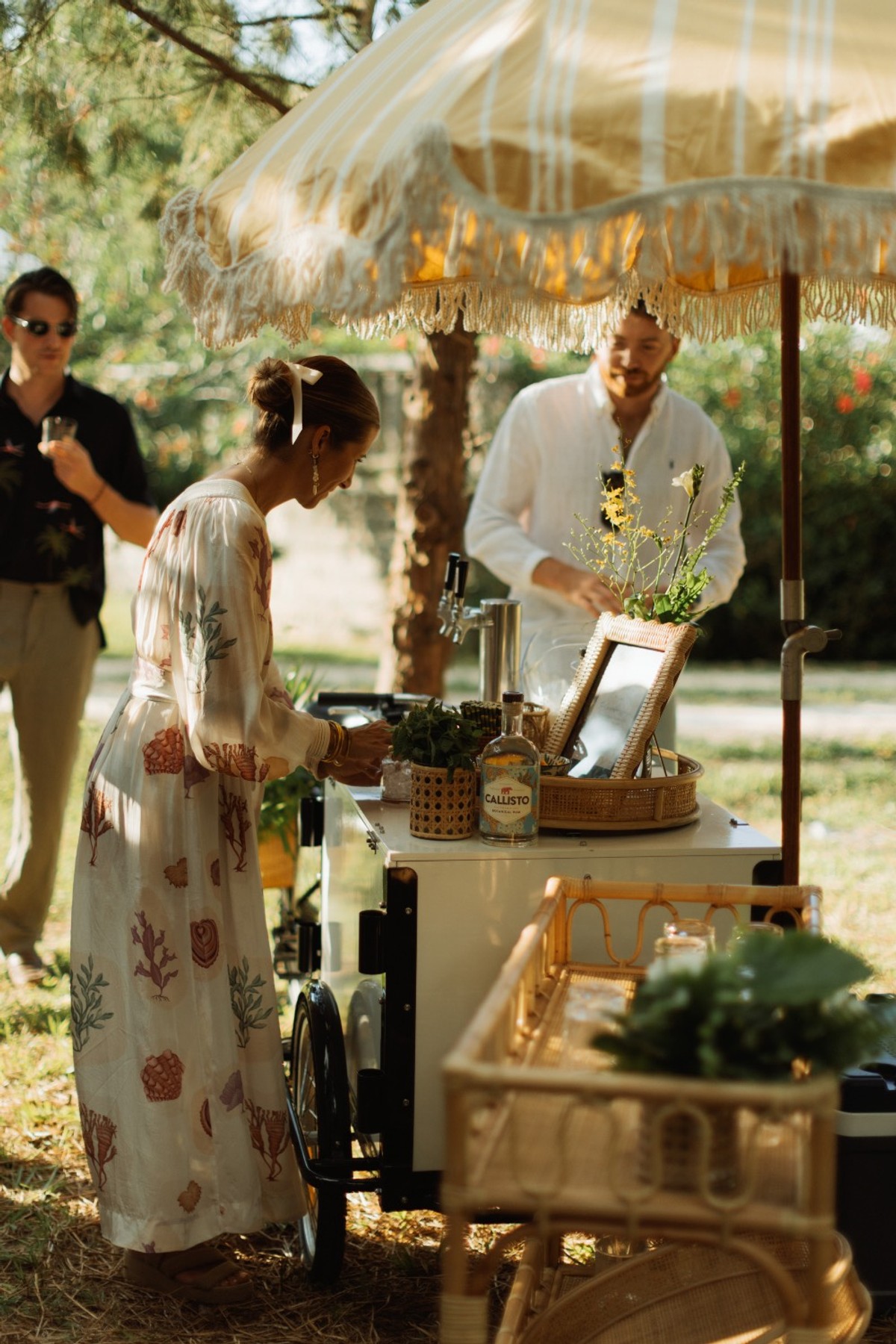 Guests being served drinks from a vintage bar cart on the garden lawn