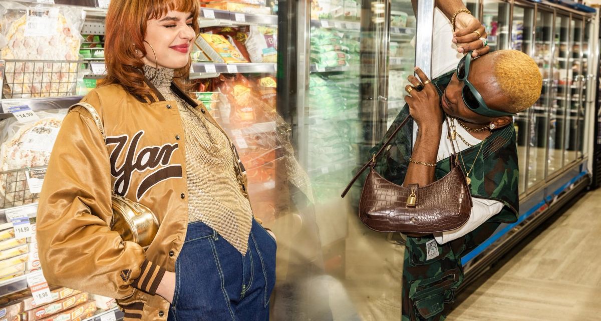 Two models in vintage jackets browsing the refrigerated aisle with a leather bag
