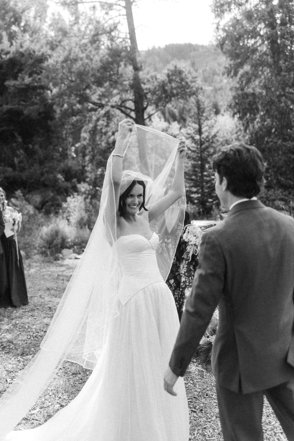 Owen lifts Devin's veil at the altar at a mountain ranch among the aspens, black and white