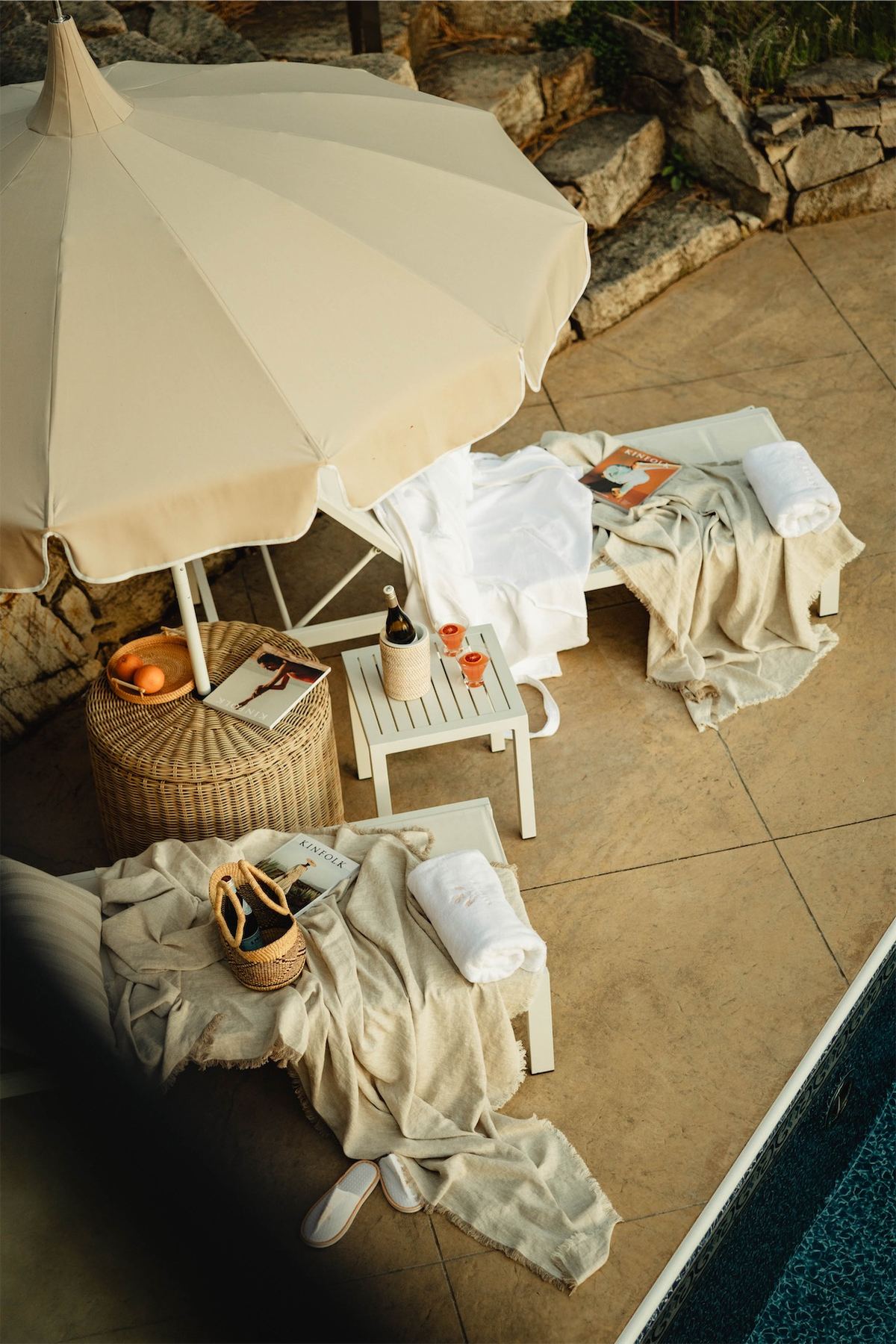 Overhead of robes, loungers and a canvas parasol on the pool terrace