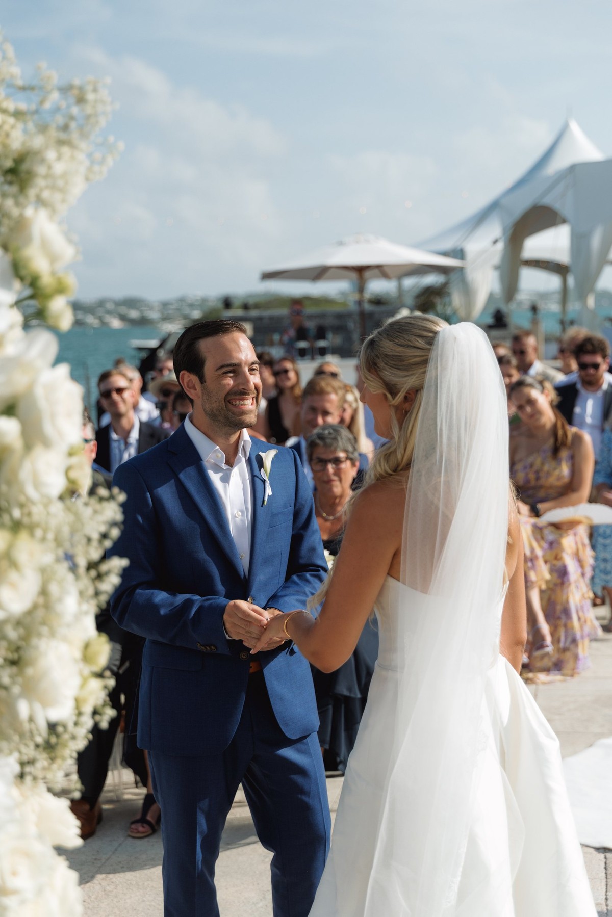 Paige and Cam hold hands at the altar in front of the guests on Hawkins Island, Bermuda