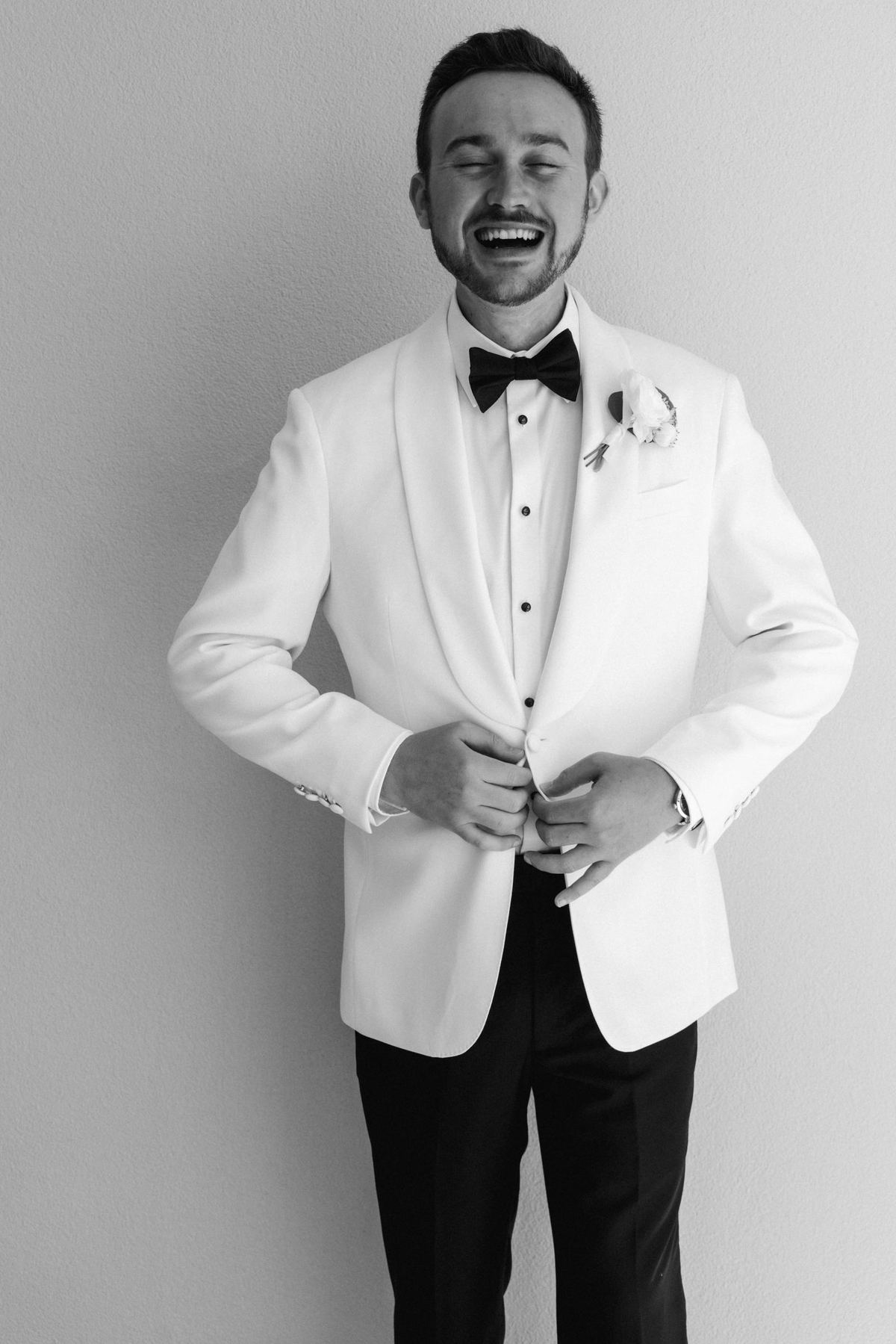 Black and white classic portrait of groom in white tuxedo at Bermuda wedding