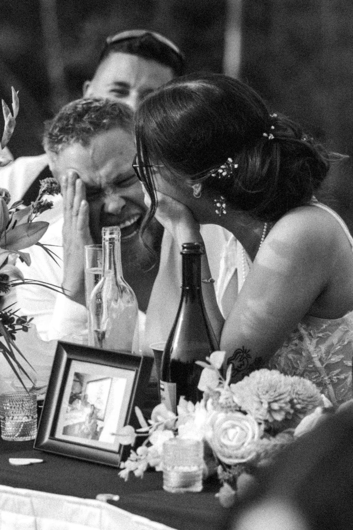 Black and white emotional moment between guests at the reception table