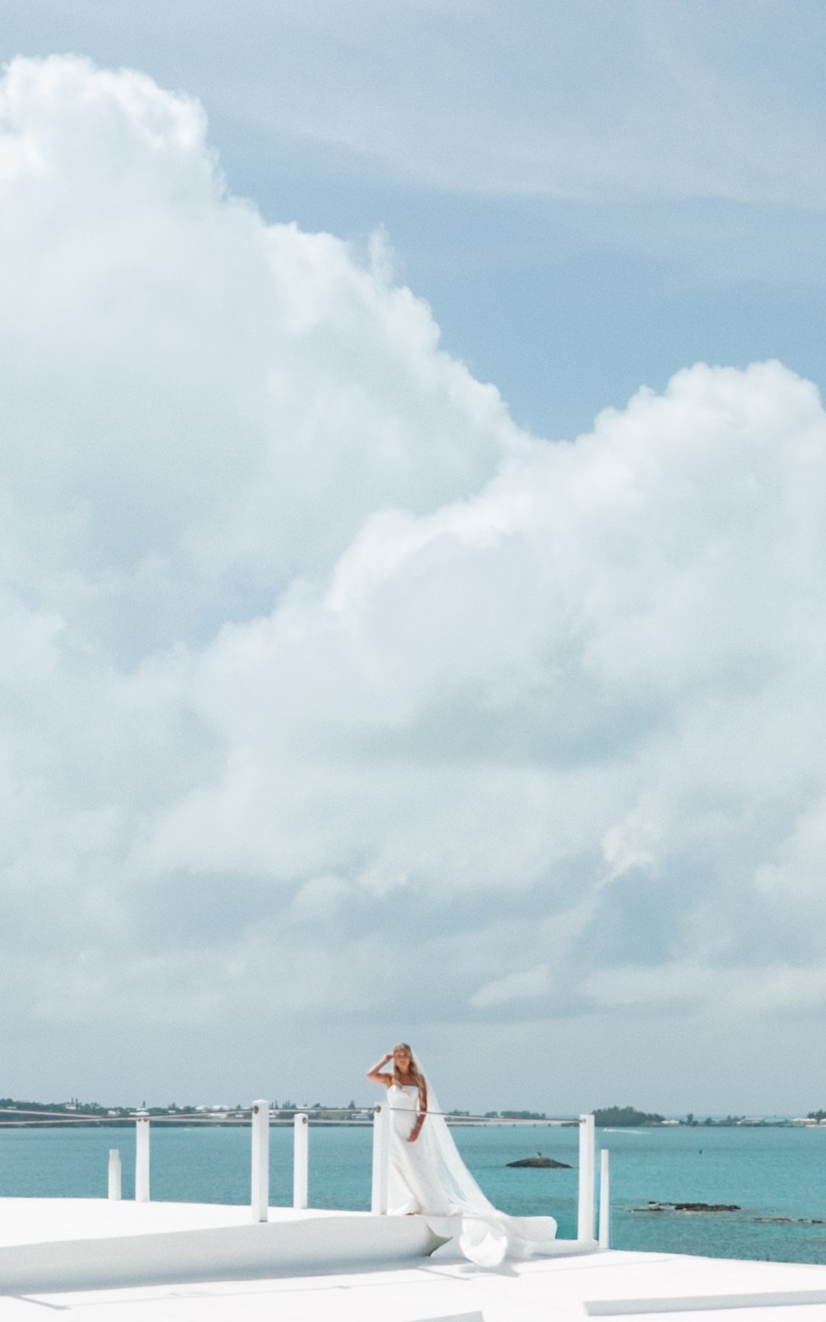 Paige stands on the rooftop terrace under towering summer clouds on Hawkins Island, Bermuda