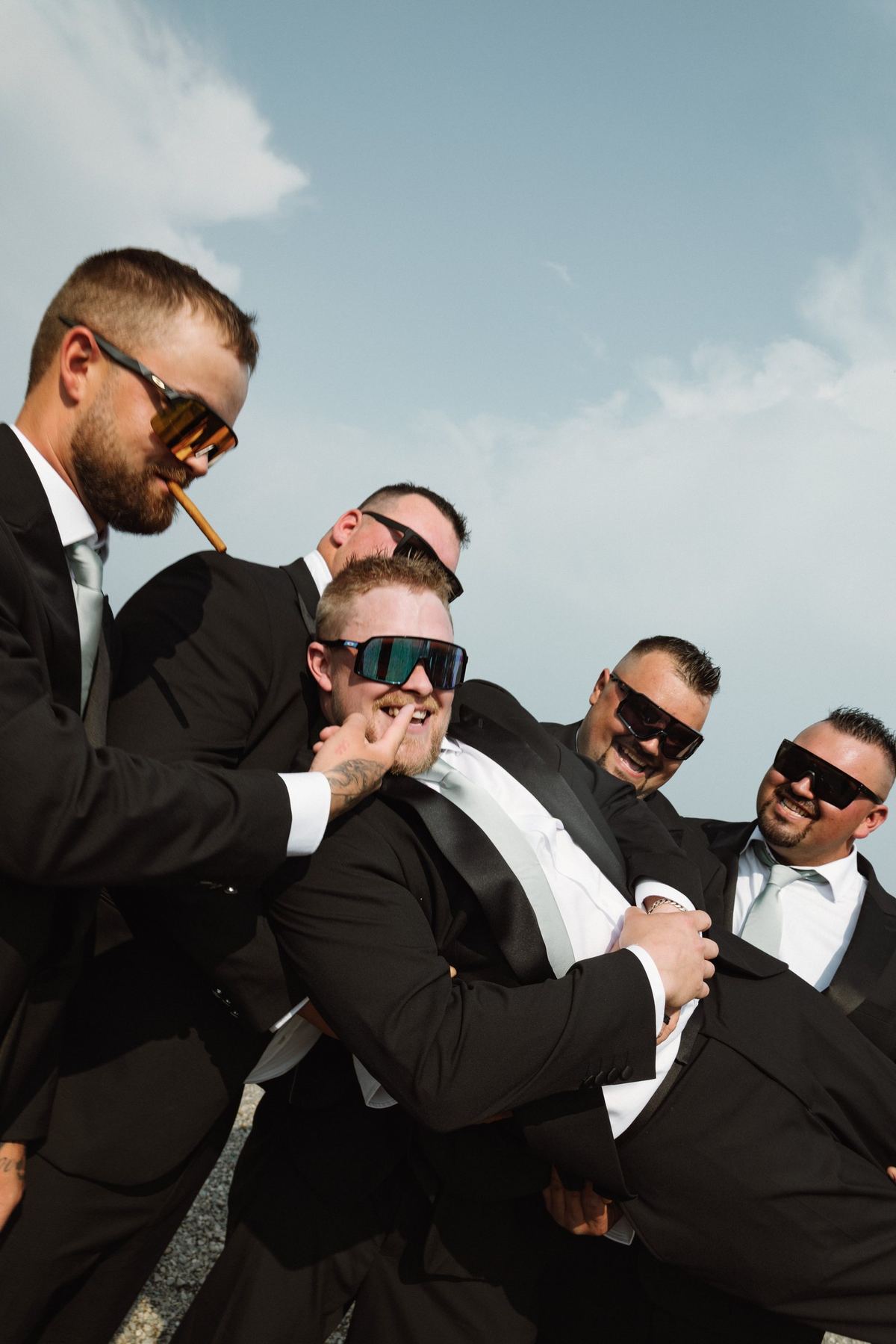 Groomsmen goofing around with a cigar after the ceremony