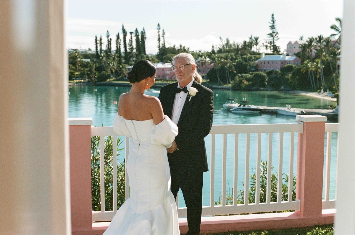 Bride and her father share a first look on a pink balcony above the harbour