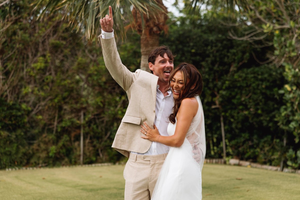 Bride and groom celebrating with an arm thrown up after their ceremony