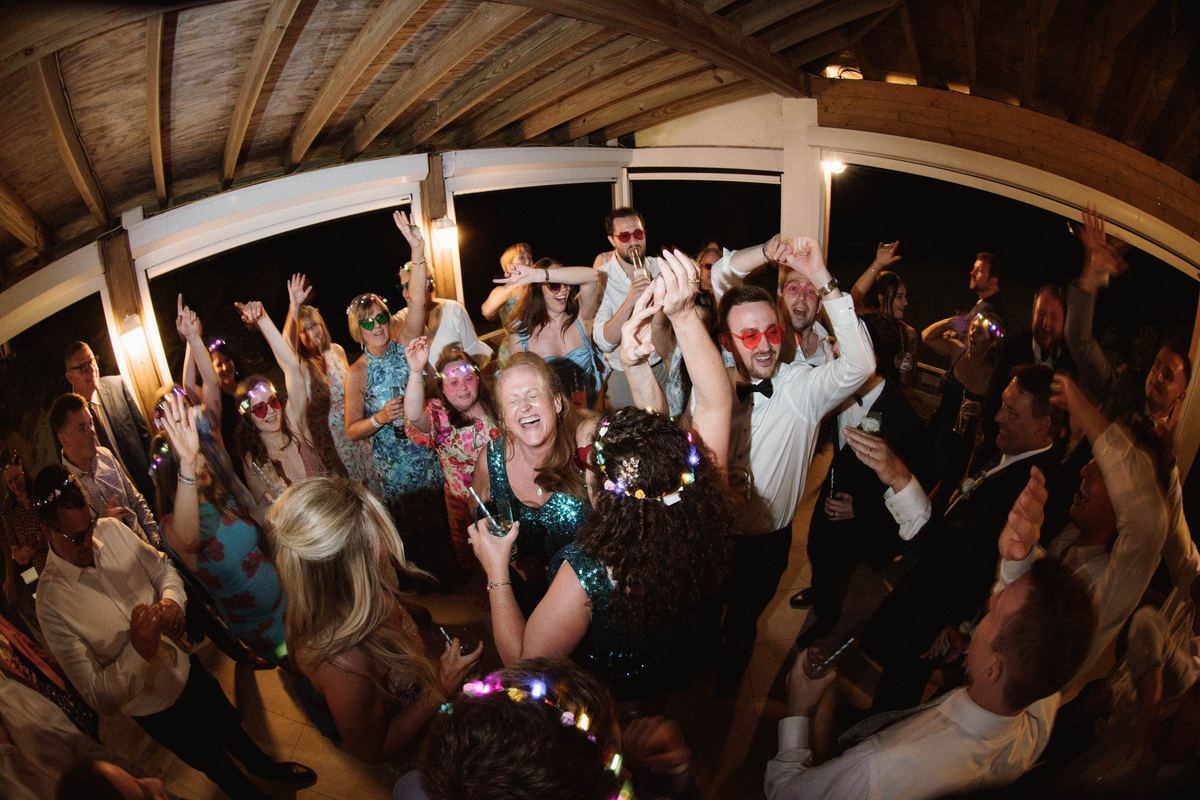 Crowded dance floor with guests' hands raised at Bermuda wedding