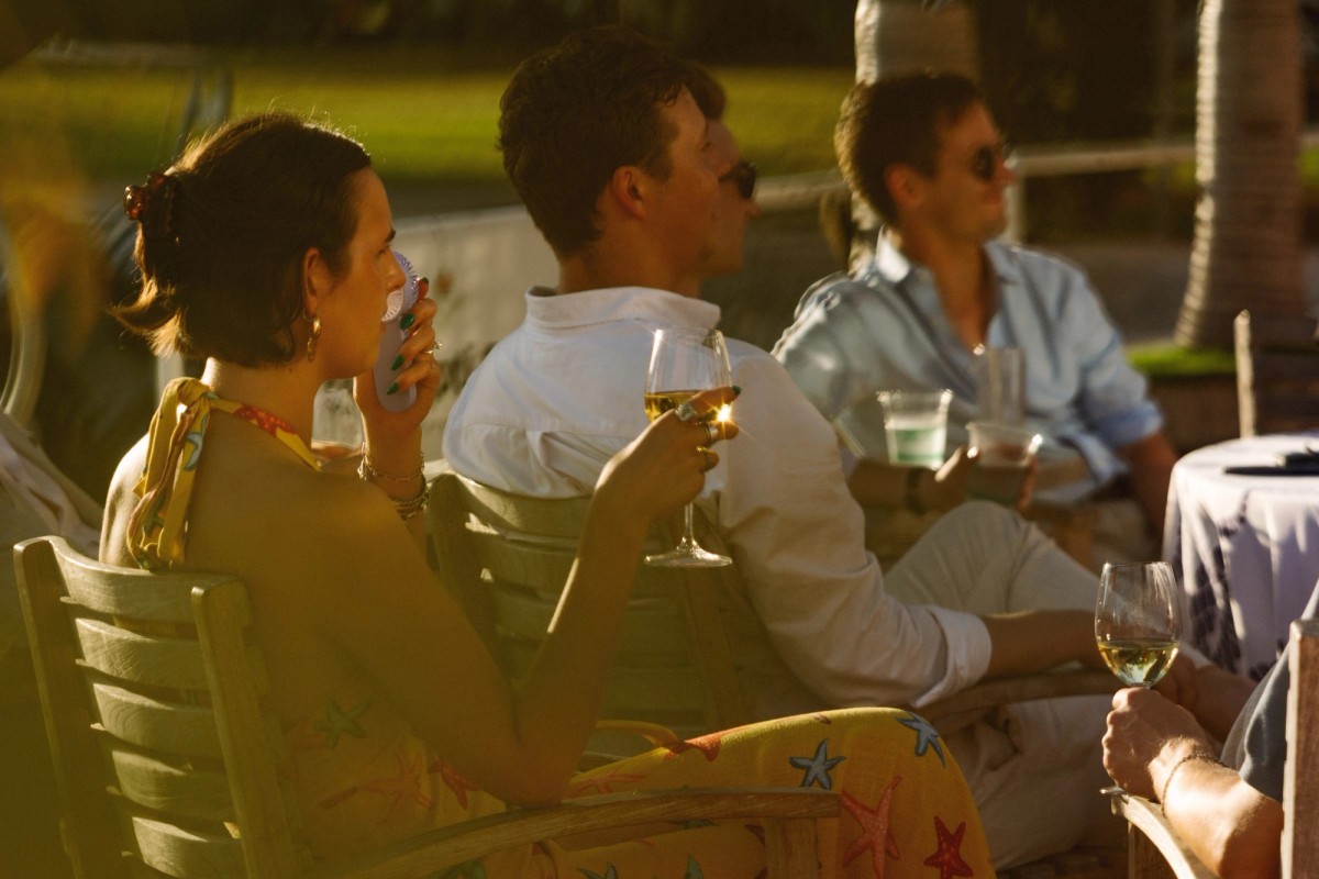 Guests sip white wine in the warm evening light at the welcome party in Bermuda