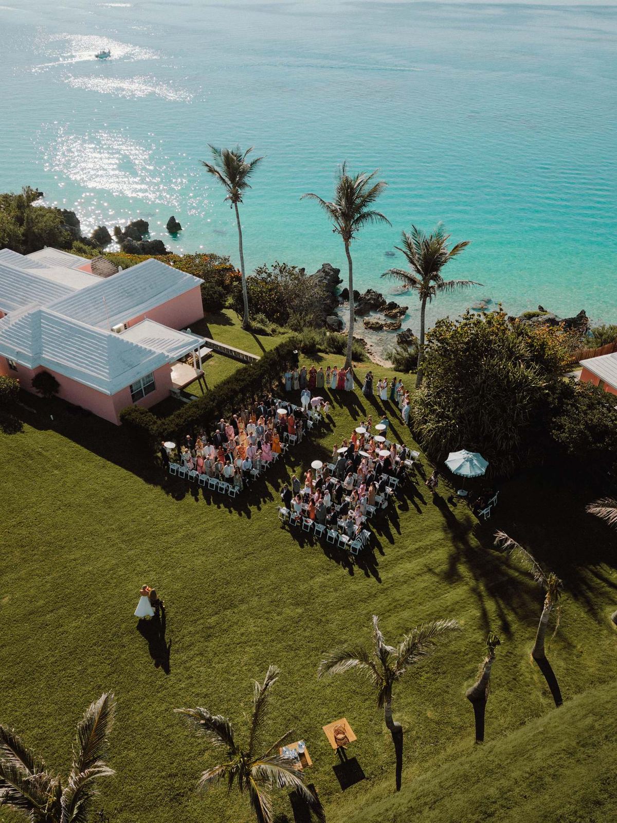 Aerial view of an oceanfront ceremony beside a pink Bermuda resort