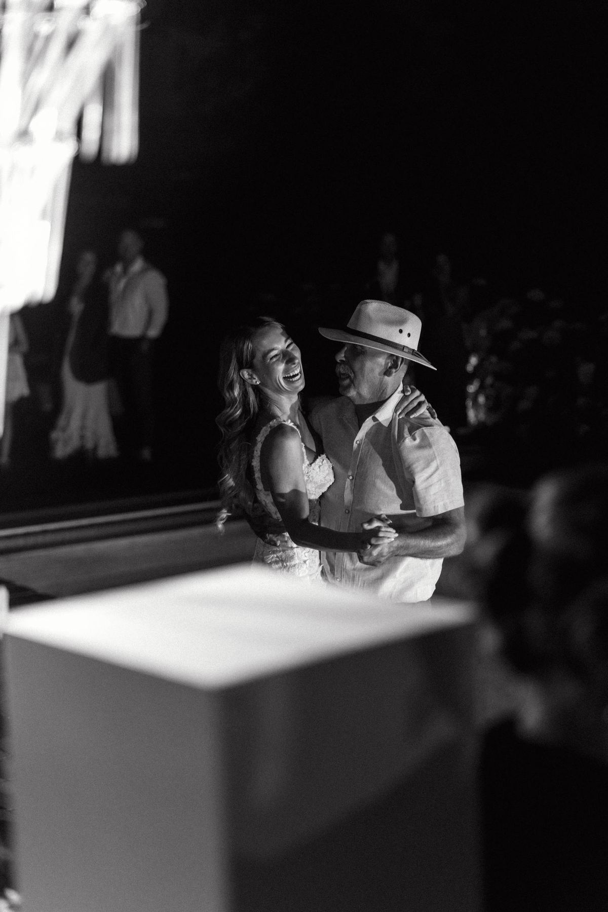 Black and white photograph of the bride and groom laughing close together
