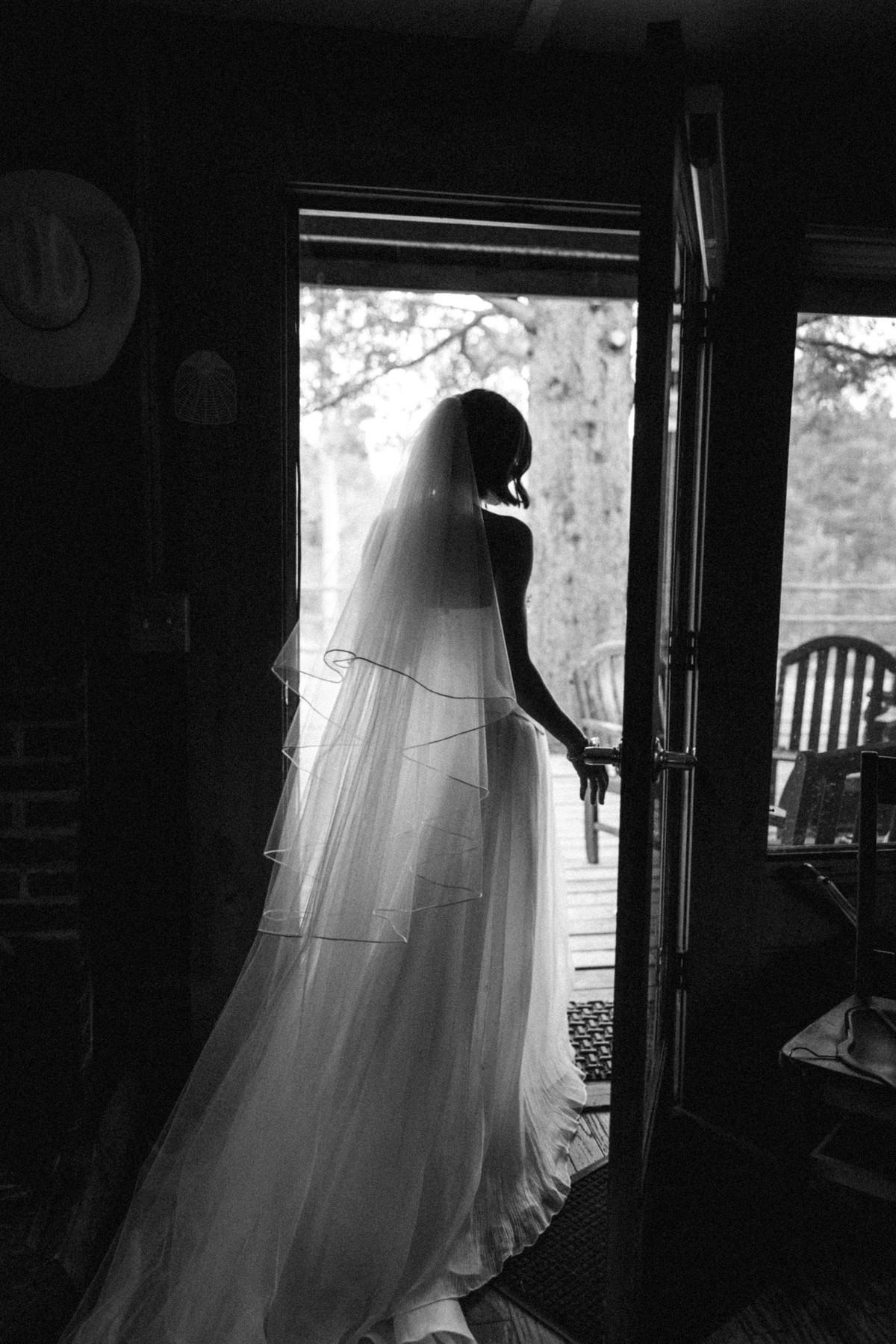 Devin in her veil silhouetted in the cabin doorway at a mountain ranch among the aspens, black and white