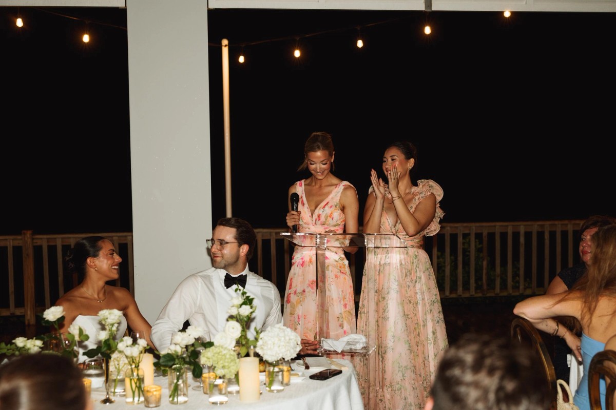 Bridesmaids giving a speech under string lights at night at Rosewood Bermuda